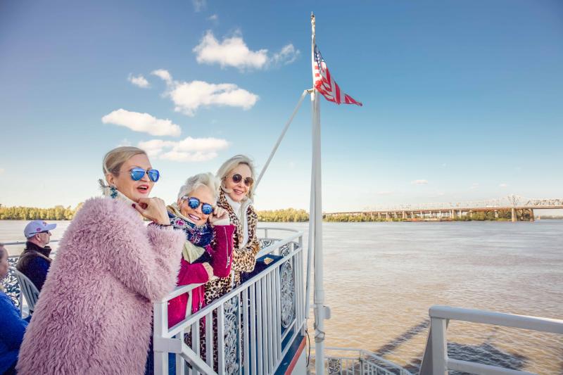 three women pose on dock of boat