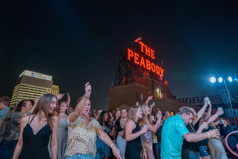 people dancing on peabody rooftop during rooftop party