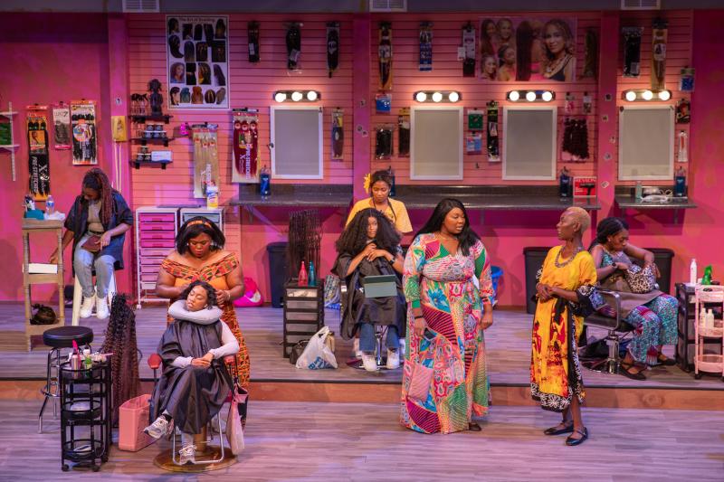 Hattiloo production of "Harlem Hair Salon," showing women at work braiding hair.
