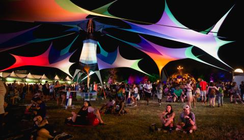 Guests relax around the grounds of Mempho Music Festival. Multicolored tents provide shade.