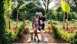 two women smile for photo in garden arch Photo