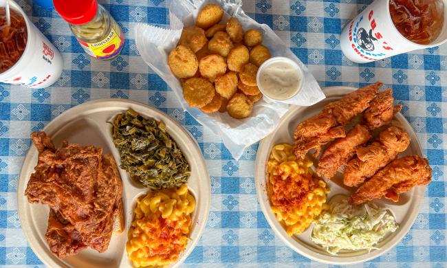 overhead shot of multiple plates of fried chicken with sides and fried pickles from Gus'