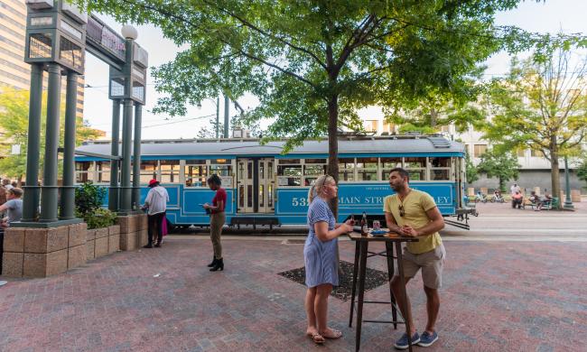 people hanging outside with blue trolley in background
