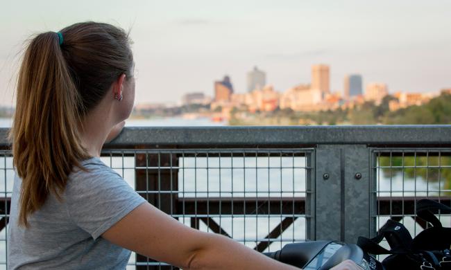 woman on big river crossing bridge looks at Memphis skyline