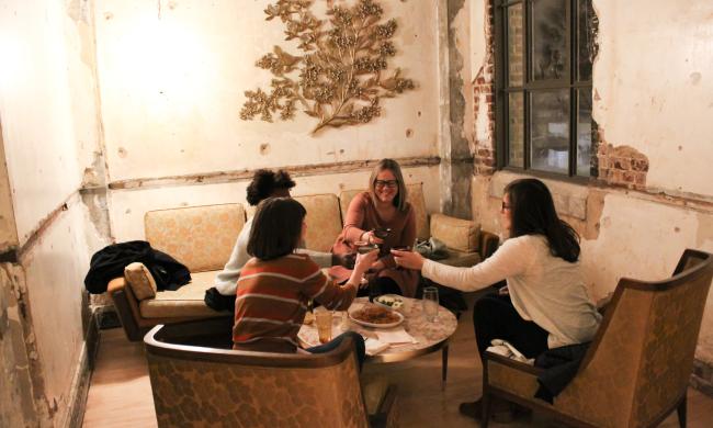 A group toasting glasses at a table at Art Bar