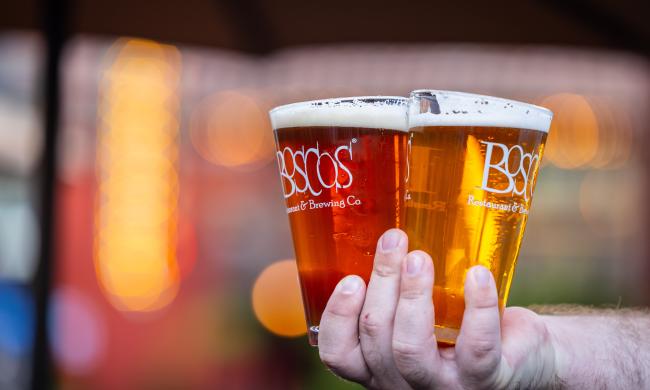 two bosco beer pints held in a hand