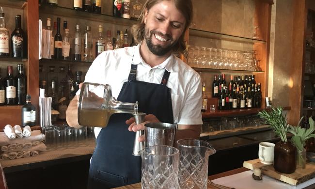 bartender makes cocktail behind Bari Ristorante e Enoteca bar