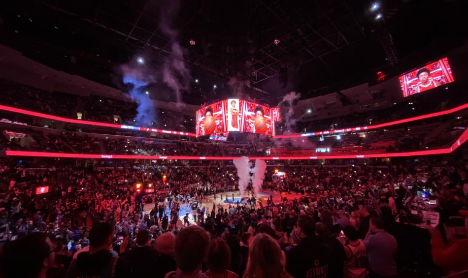 wide shot from inside fedexfforum during grizzlies game. lights are dark for pre-game video with red lights lining arena
